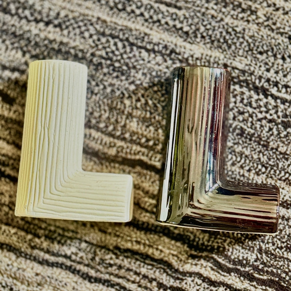 Metallic 'L' shaped object on a textured surface