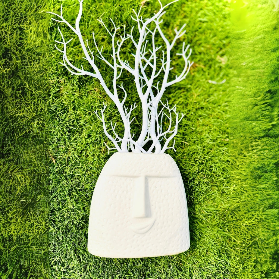 White decorative wall art with tree branches on a green moss background