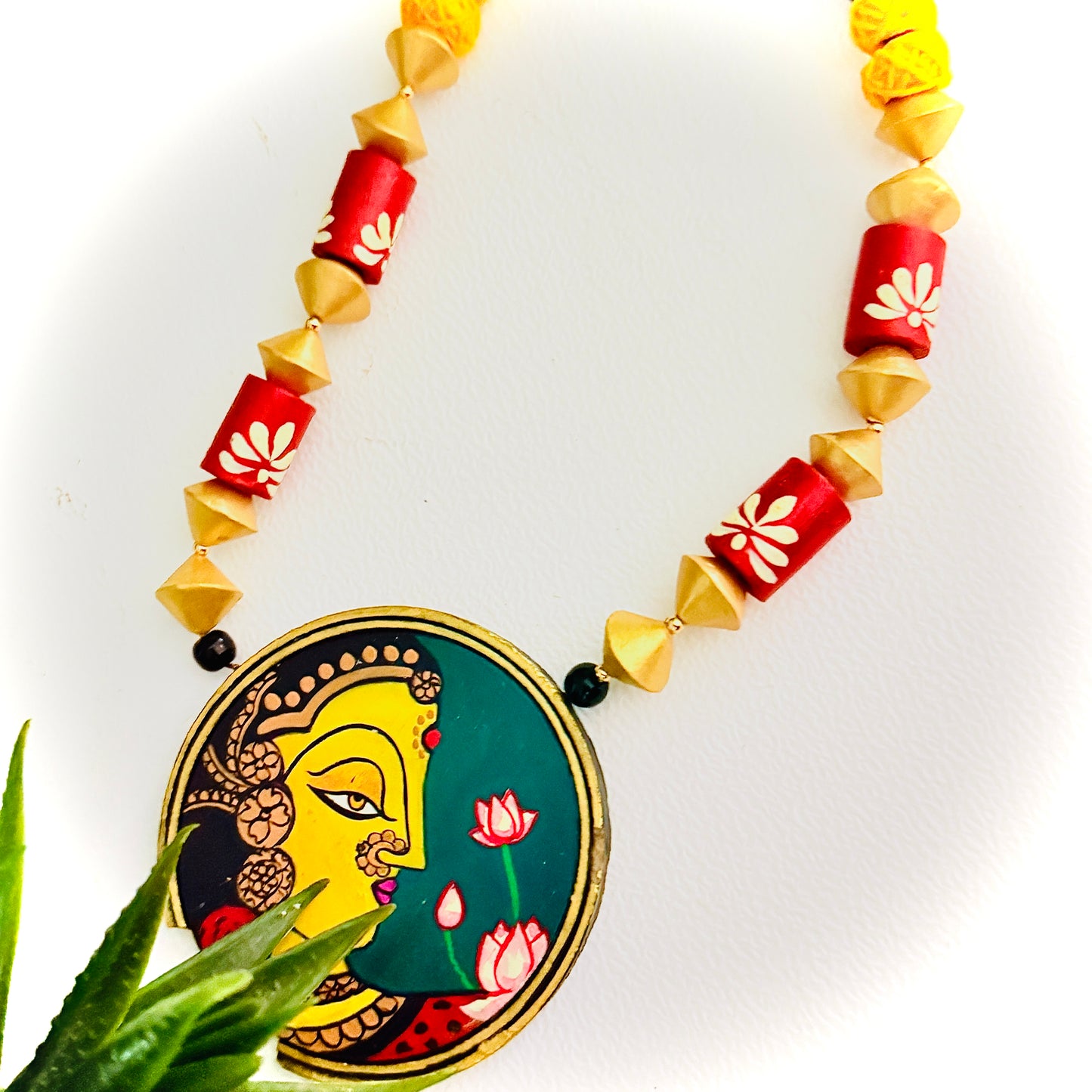 Necklace with decorative pendant featuring a face design on a white background