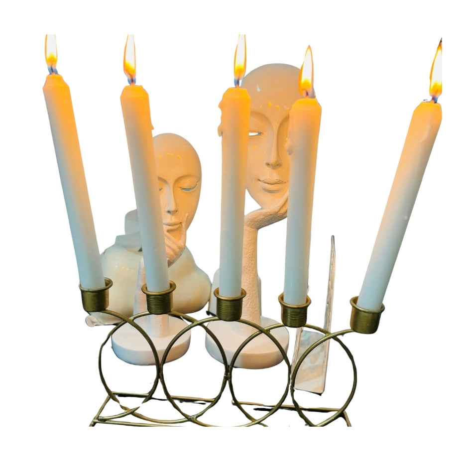 Candle holder with face-shaped candle holders and lit candles on a white background