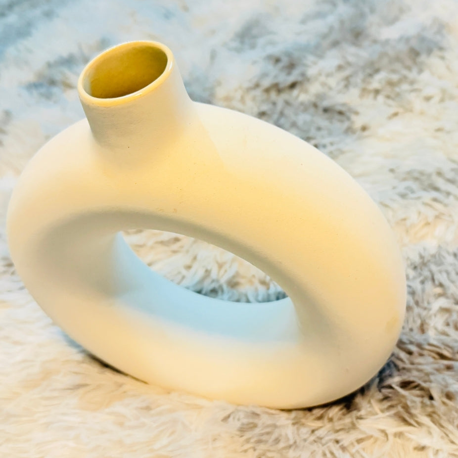 Yellow ceramic vase on a textured surface