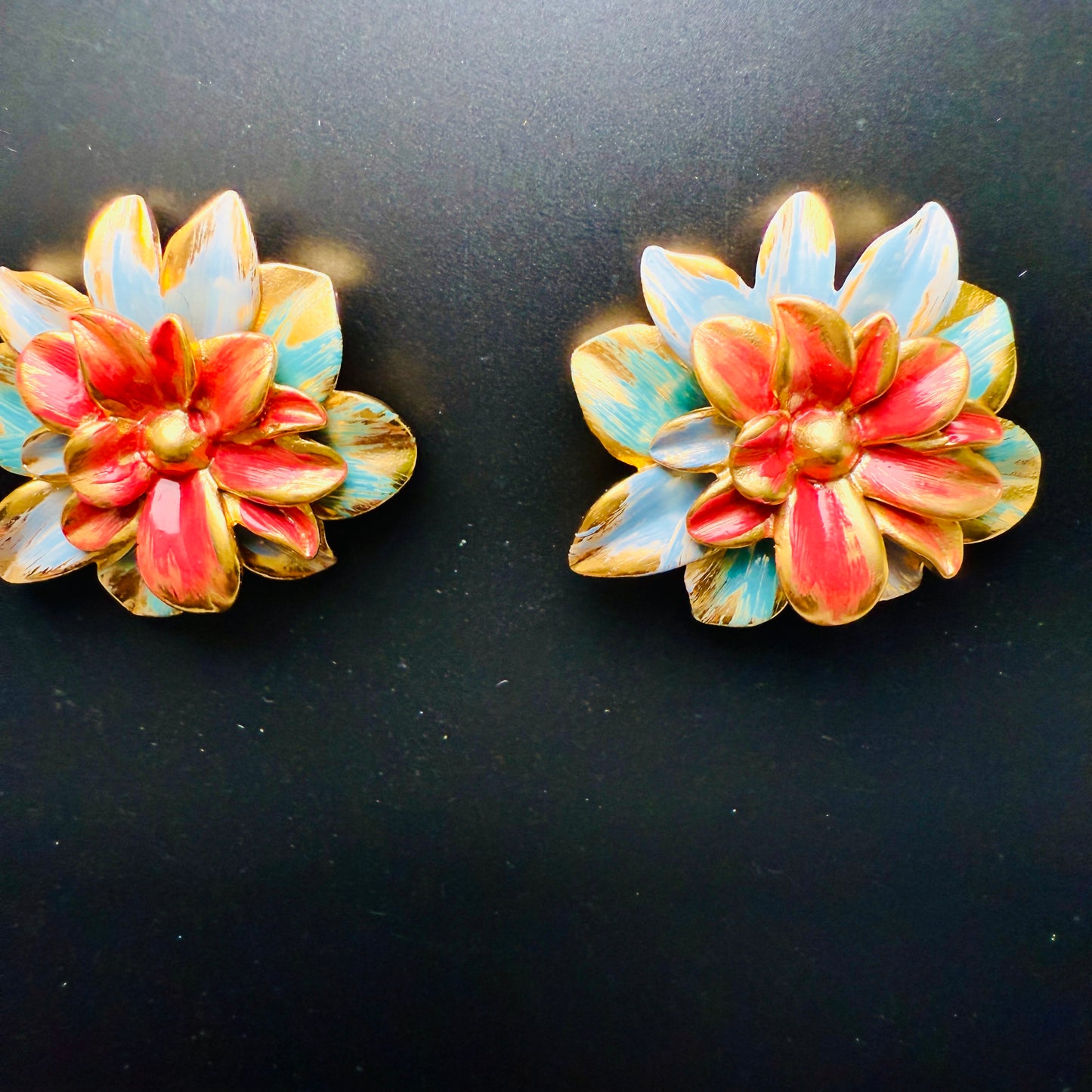 Pair of floral earrings with multicolor design on a black background