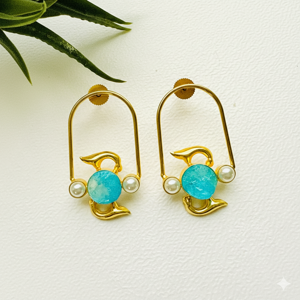 Gold dolphin earrings with turquoise stones and pearls on a white background