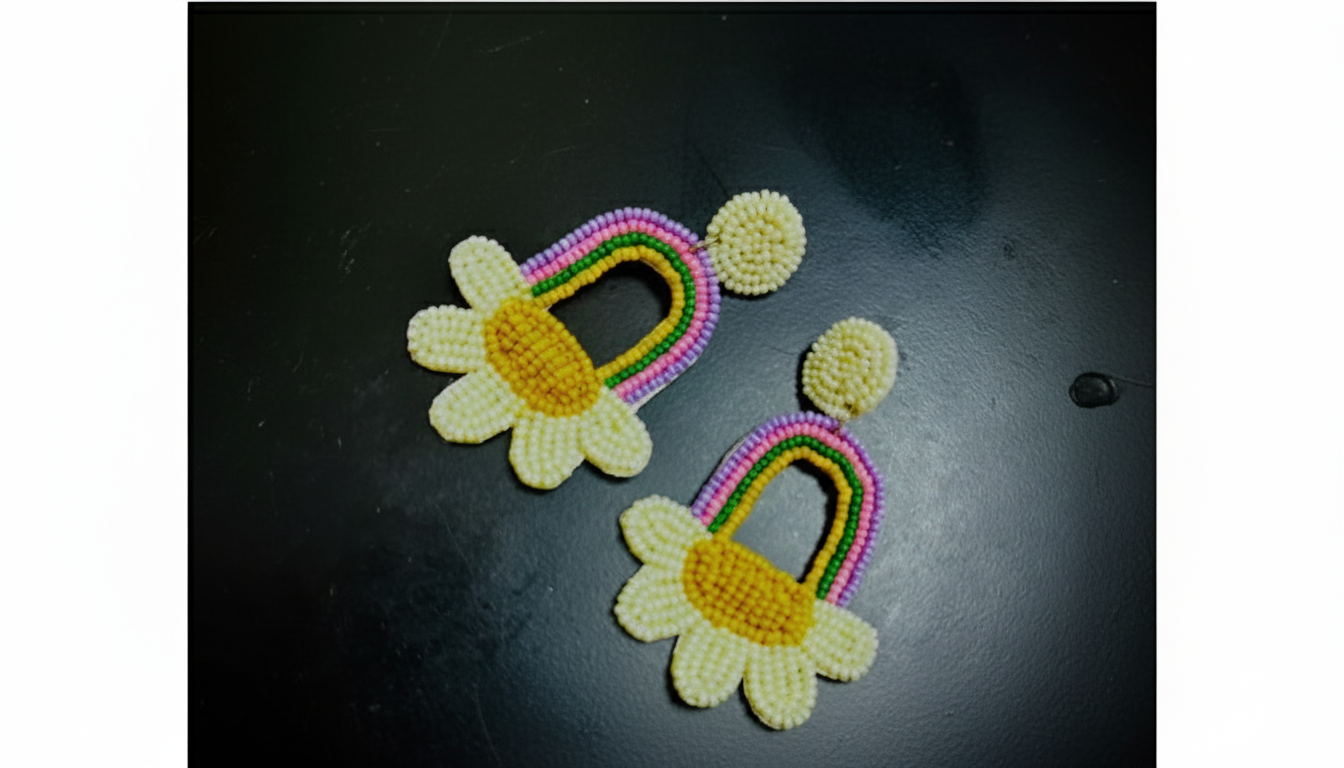 Colorful beaded earrings with flower designs on a dark surface