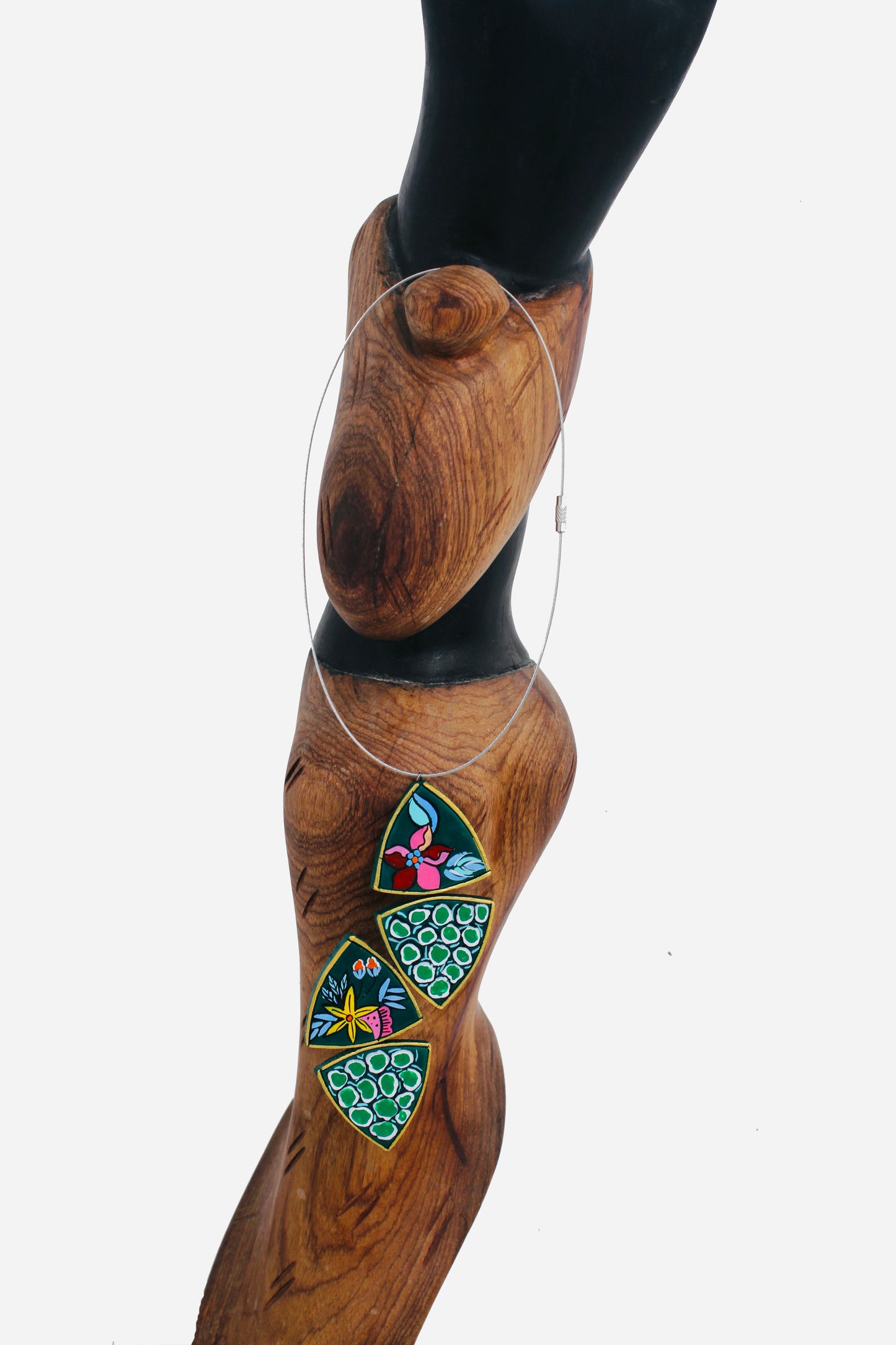 Necklace with colorful pendant on a wooden mannequin against a white background