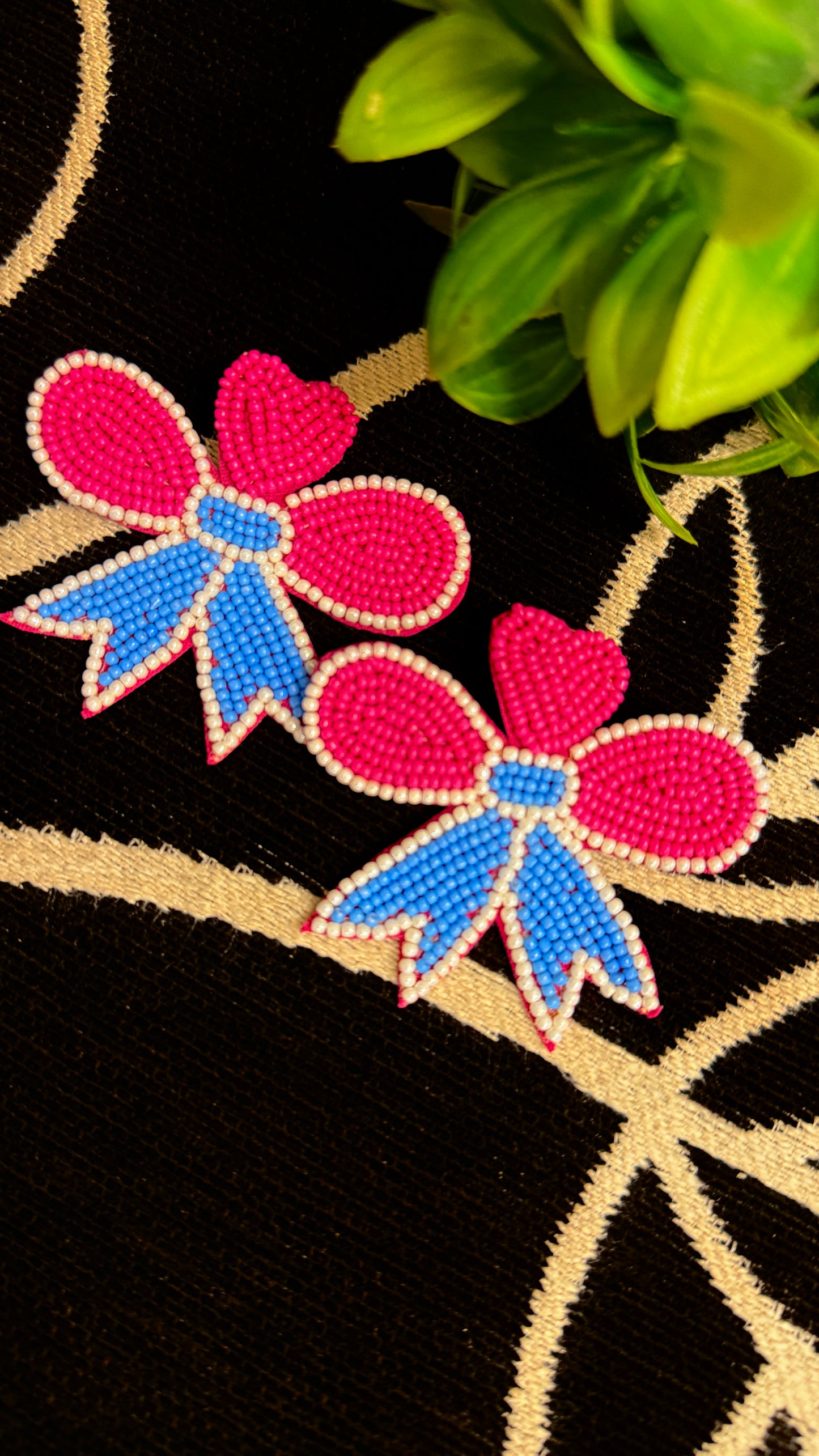 Two pink bows with blue centers on a black background
