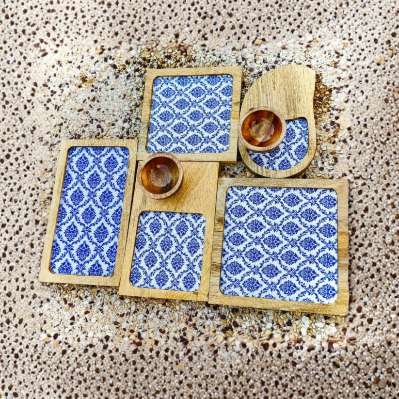 Set of wooden coasters with blue patterned designs on a textured surface