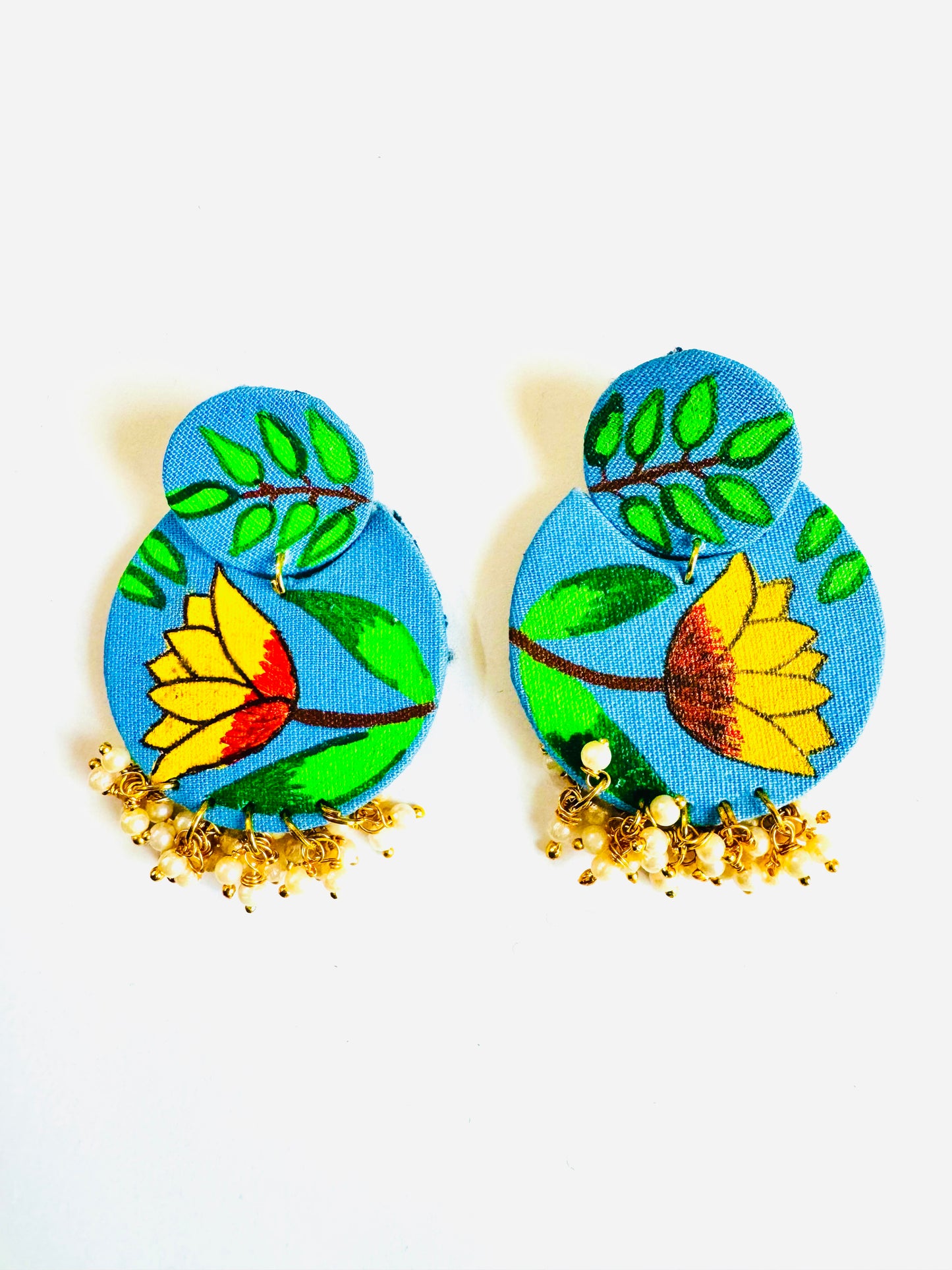 Pair of blue earrings with floral designs on a white background