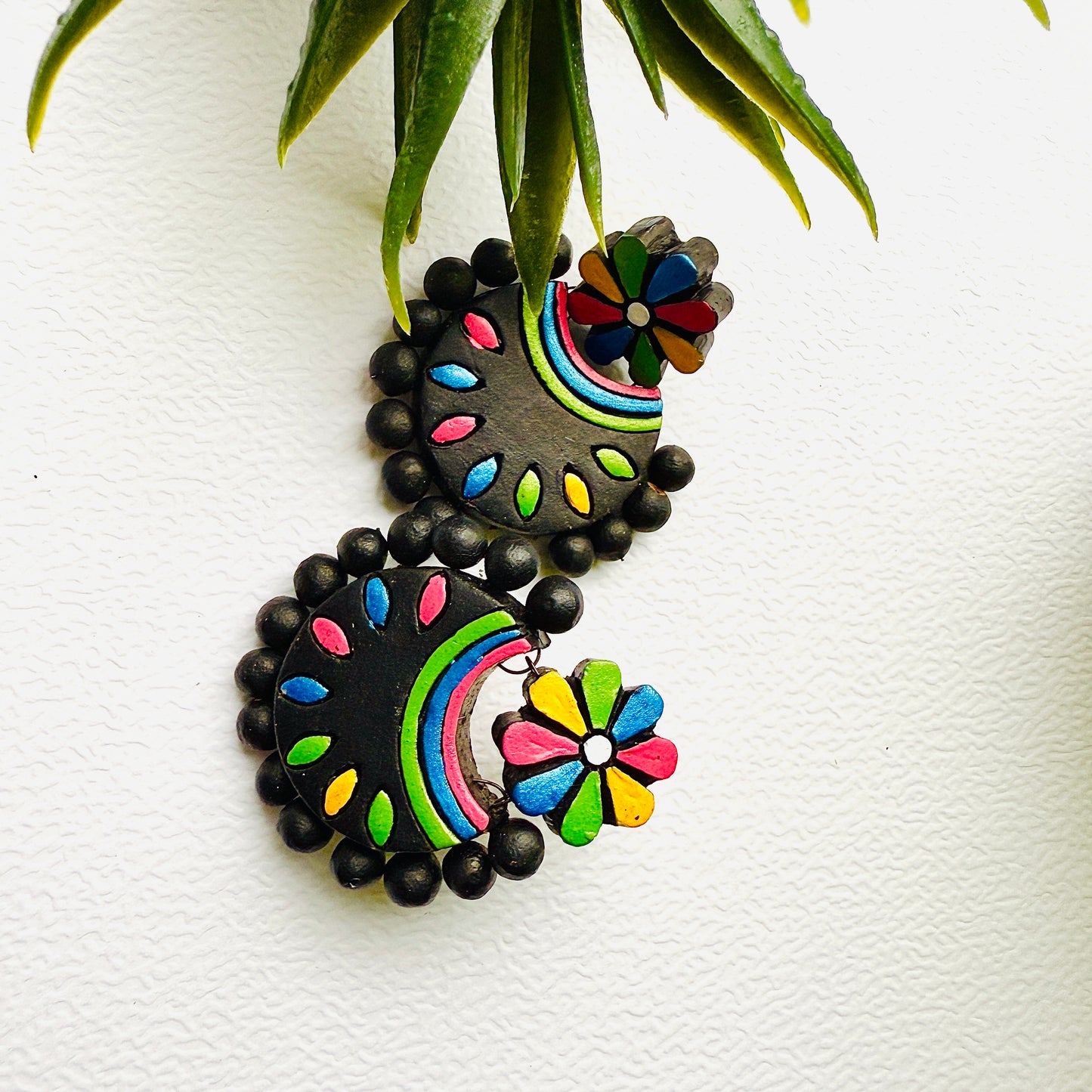 Colorful earrings with black beads on a white background