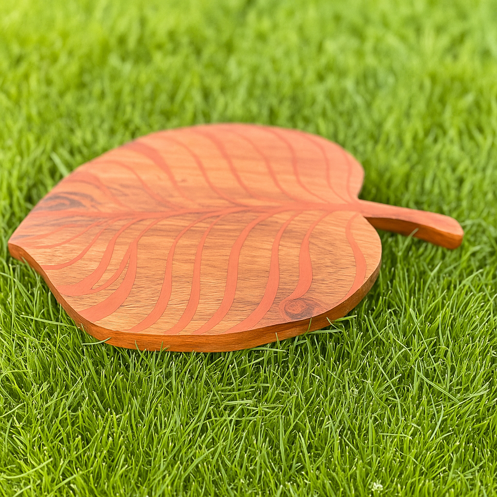 Wooden leaf-shaped cutting board on grass