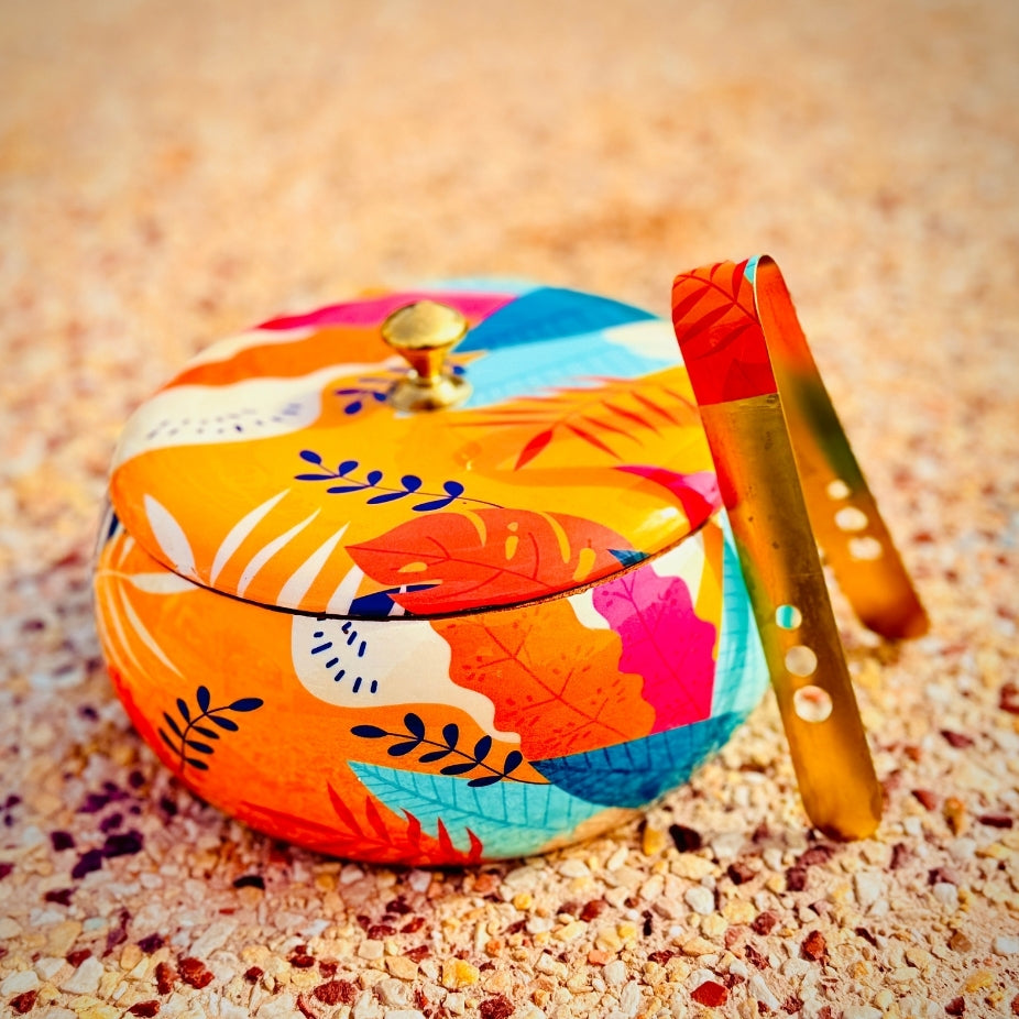 Colorful decorative box with a lid on a sandy surface