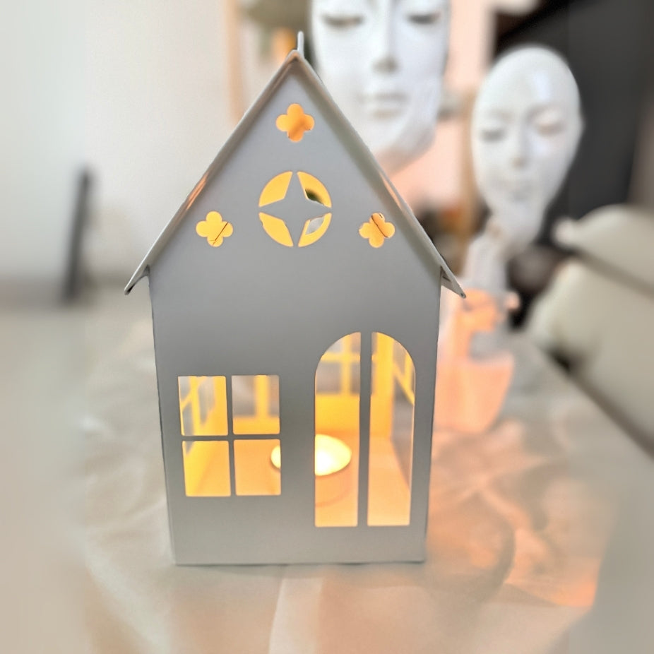 House-shaped lantern with warm glow on a blurred background