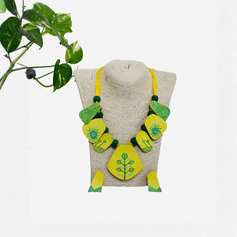Necklace with green and yellow design on a mannequin bust against a white background