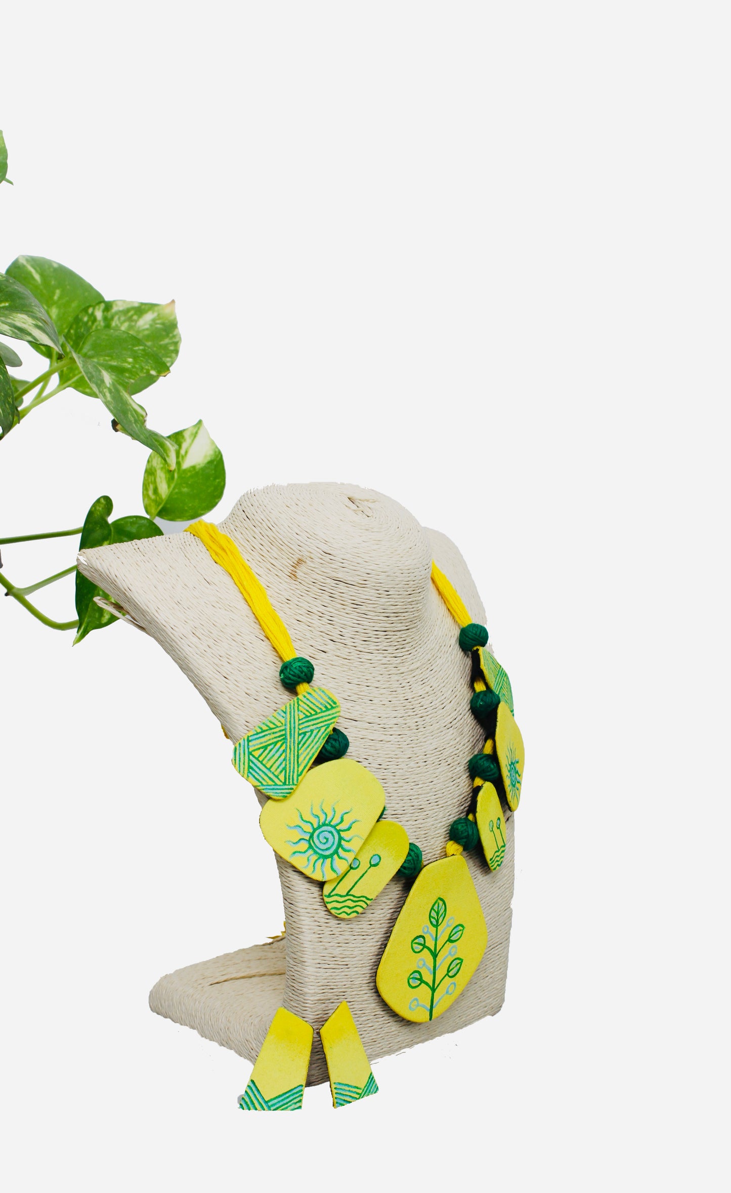 Necklace with green and yellow pendant on a white background