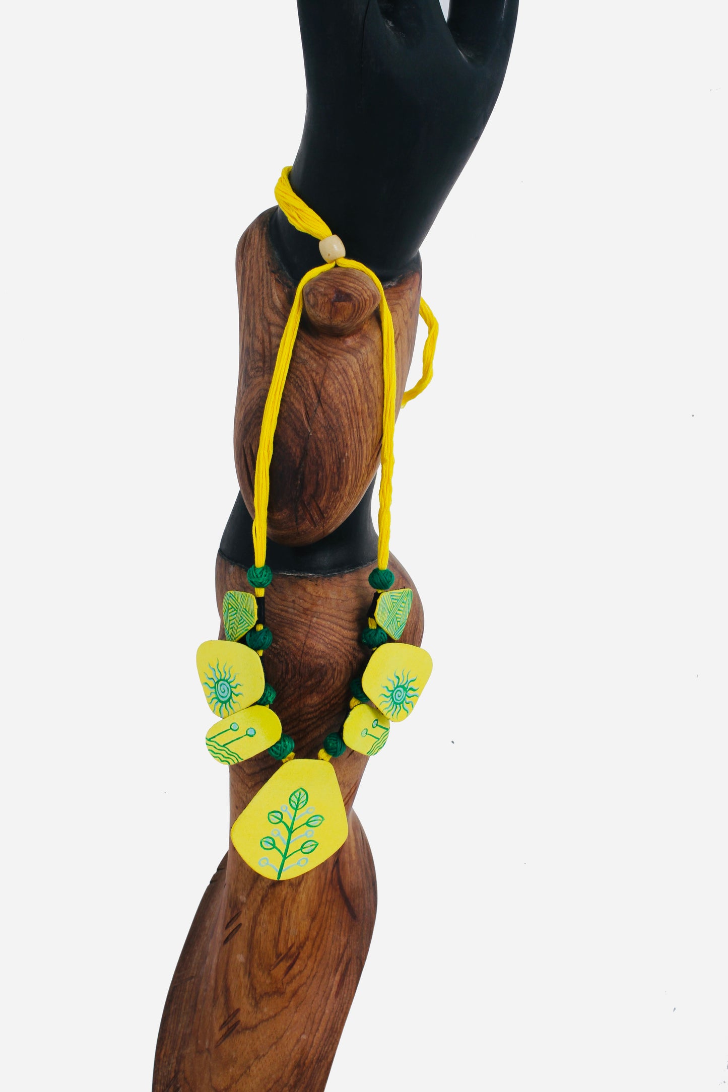 Yellow floral necklace on a wooden mannequin with a white background