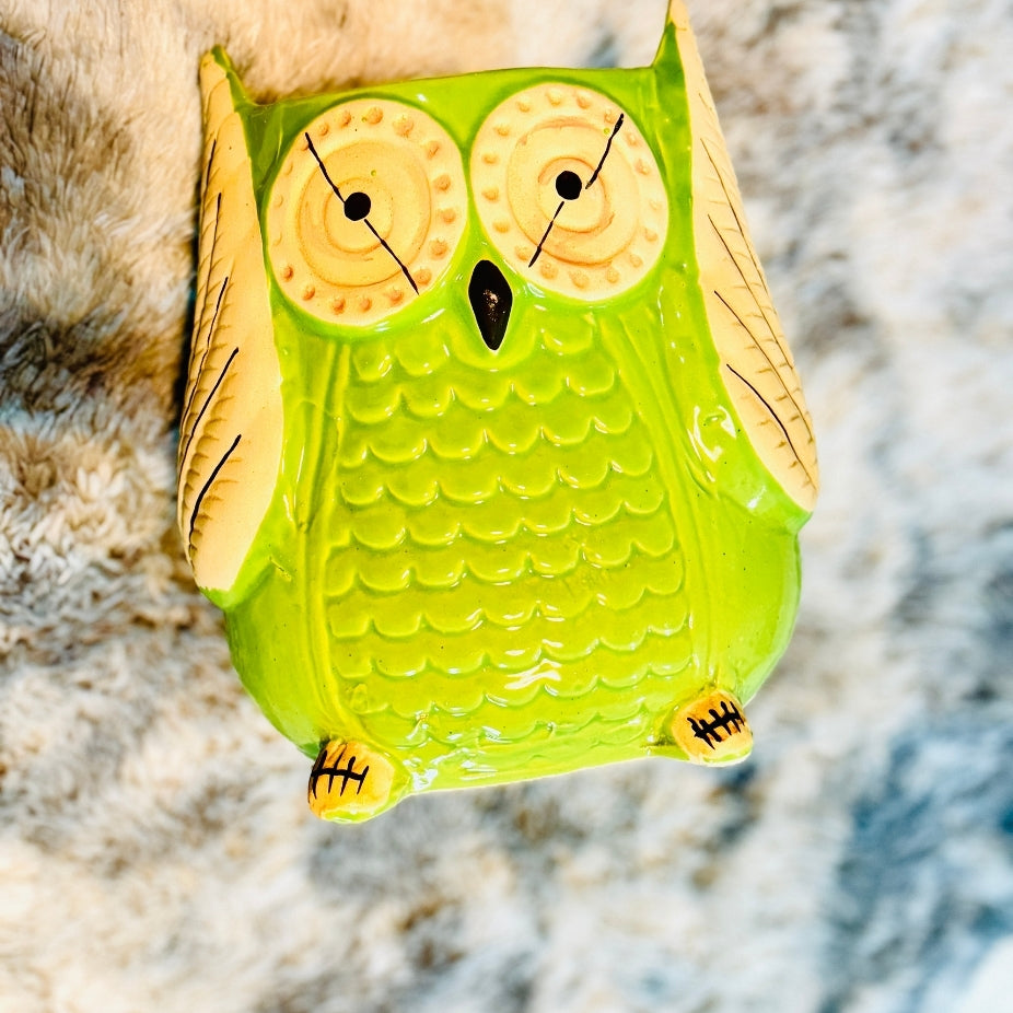 Green owl-shaped object on a textured surface