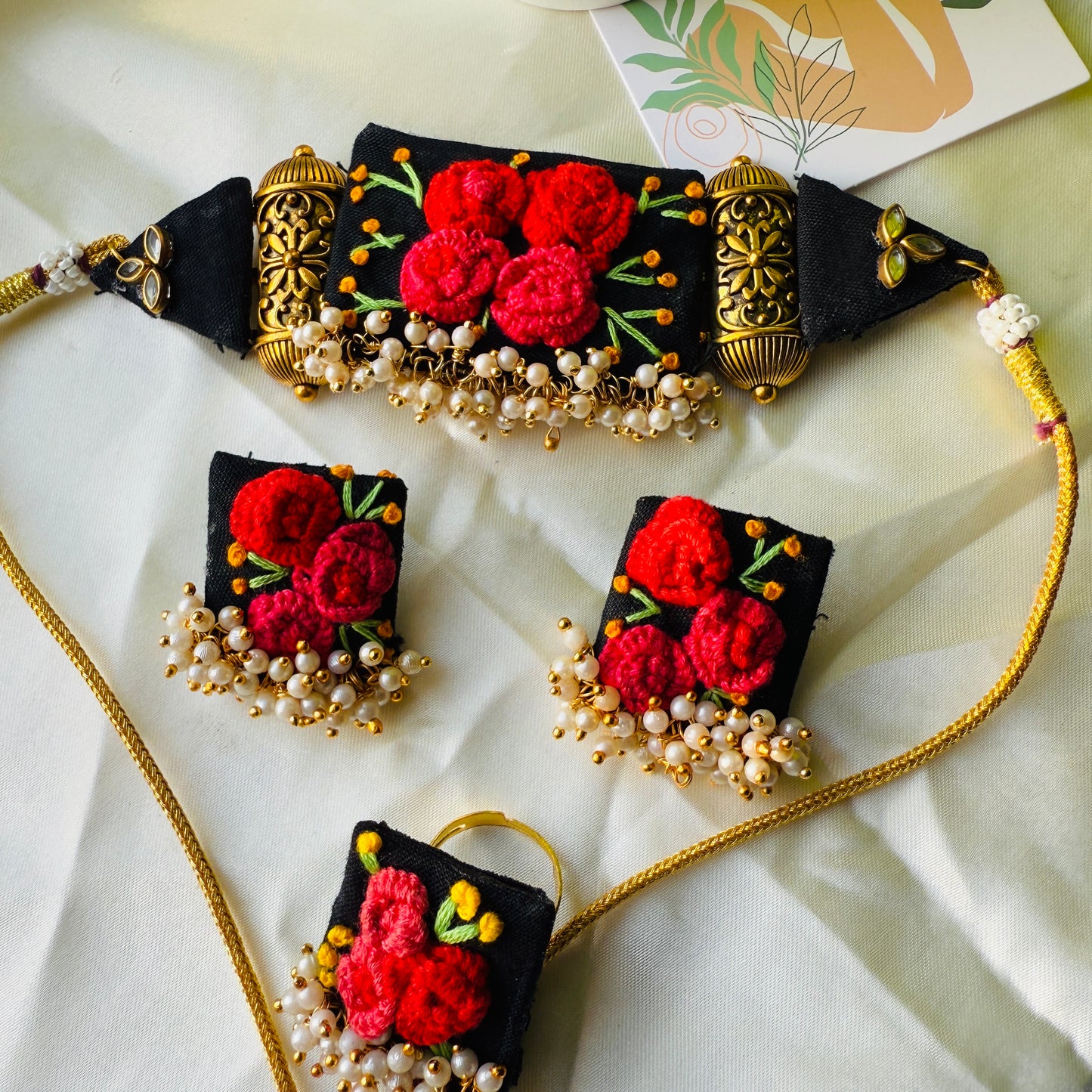 Decorative necklace with red floral patterns on a light background