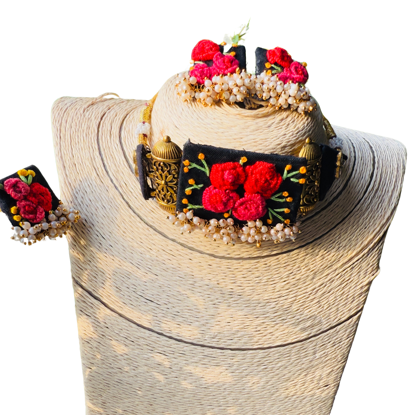 Decorative headband with red flowers and gold accents on a mannequin head.