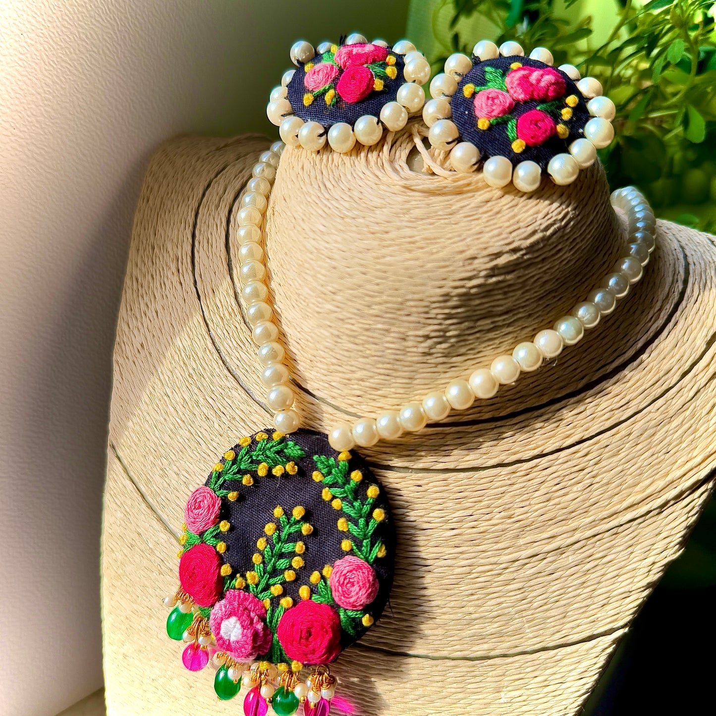 Decorative brooch with floral design and pearl-like beads on a straw surface