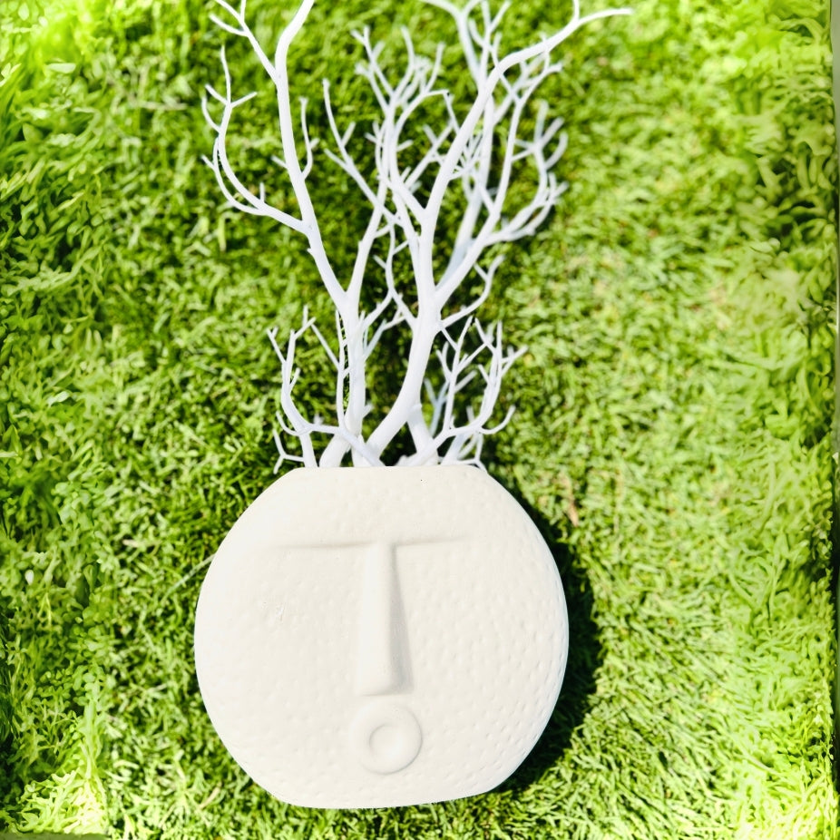 Decorative letter 'J' with white branches on a green grass-like background