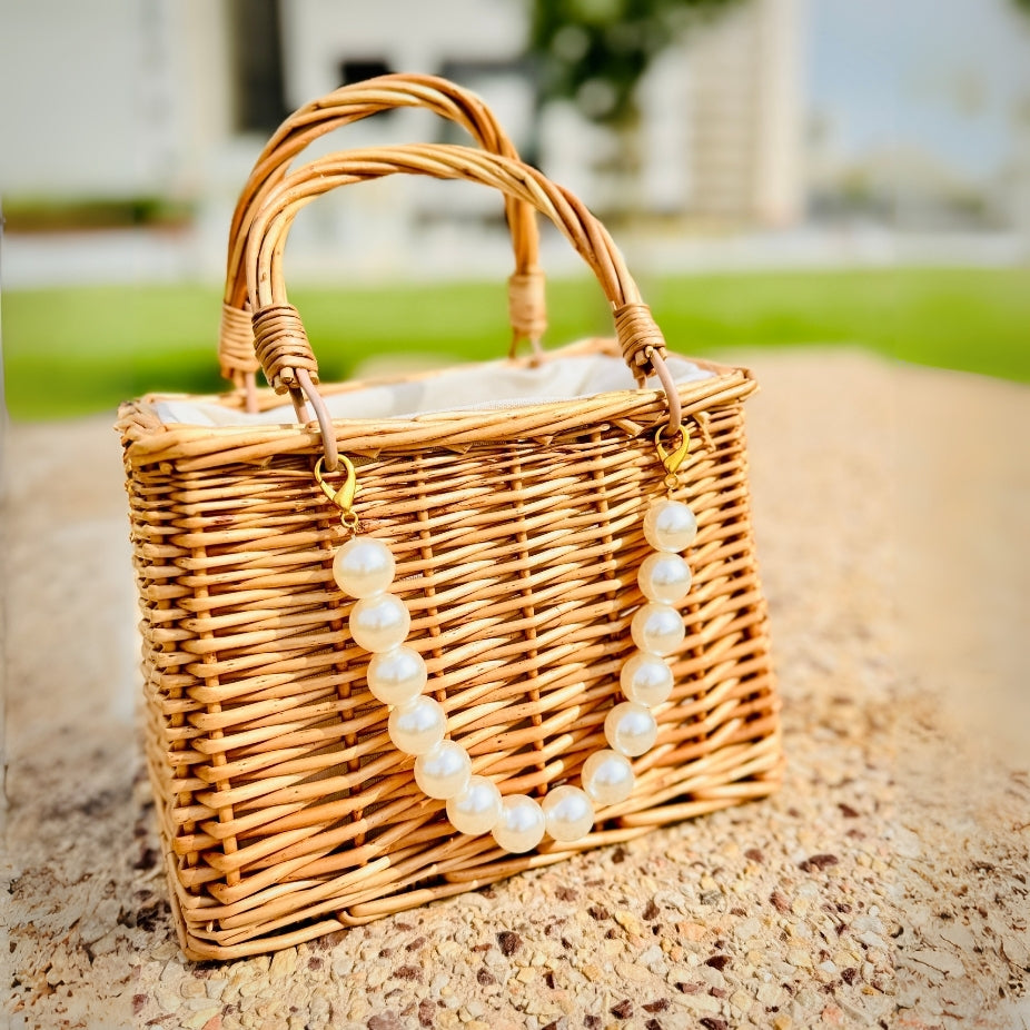 Handmade straw beach bag with large pearl detailing for a chic and trendy look