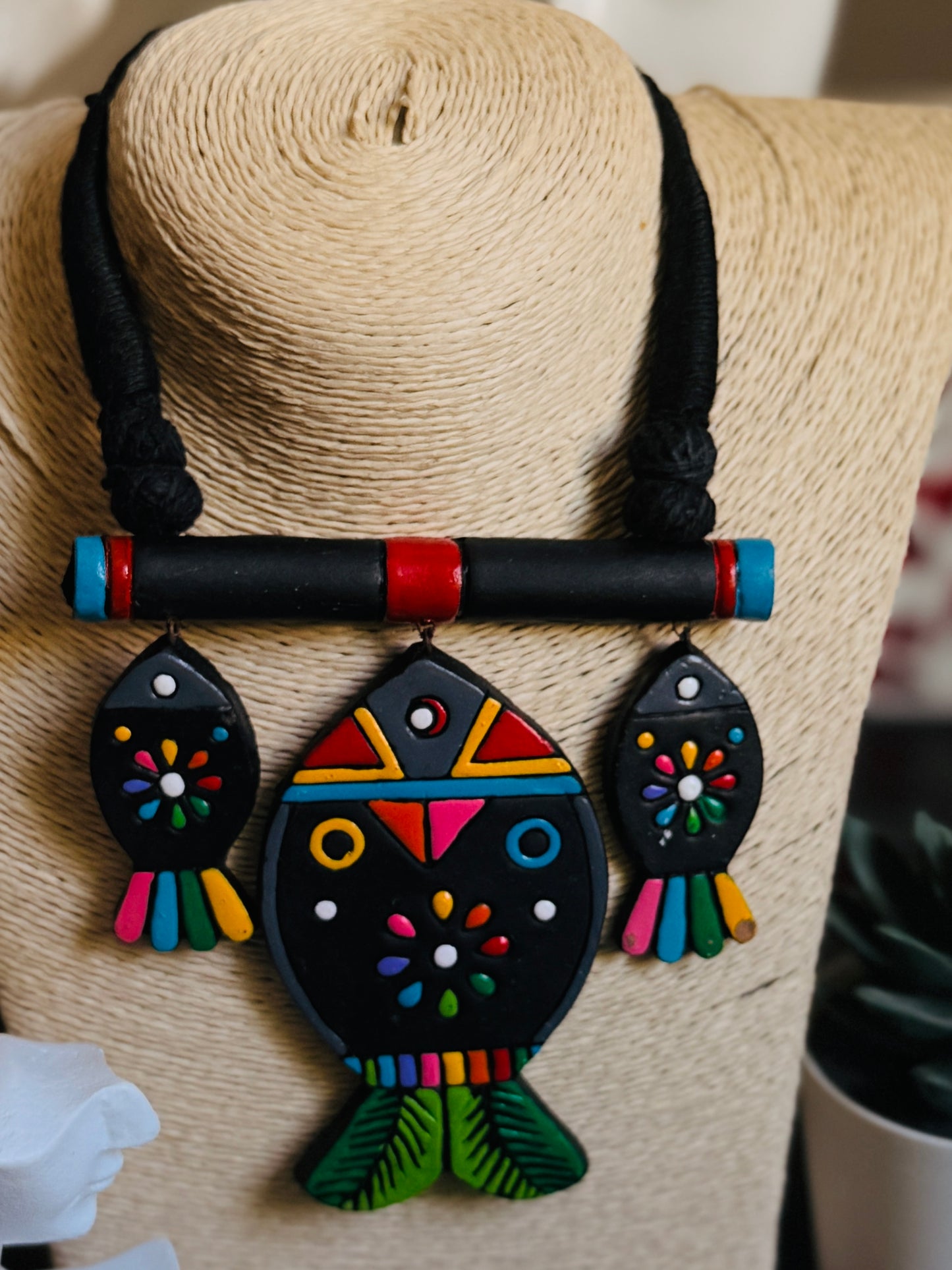 Colorful owl-shaped pendant on a straw hat