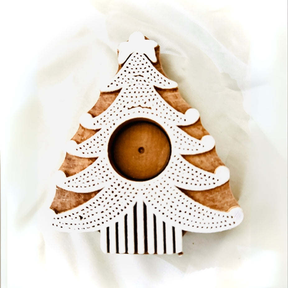 Decorative candle holder shaped like a Christmas tree with a white top and black and white striped base on a light background.