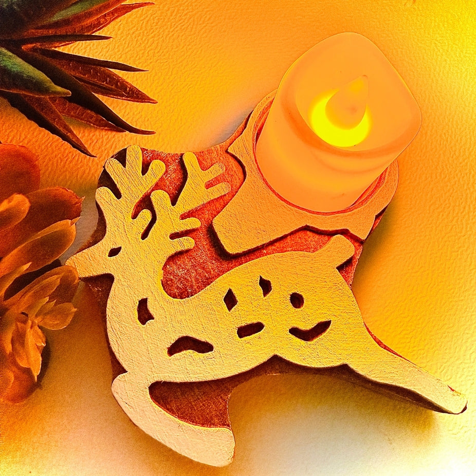 Decorative wooden reindeer ornament with a candle on an orange background