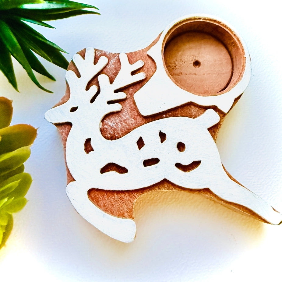 Wooden cookie cutter shaped like a reindeer with antlers on a white background.