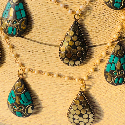 Necklace with teardrop-shaped pendants on a textured surface