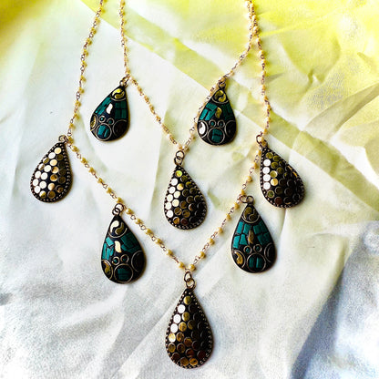 Necklace with teardrop-shaped pendants on a light fabric background