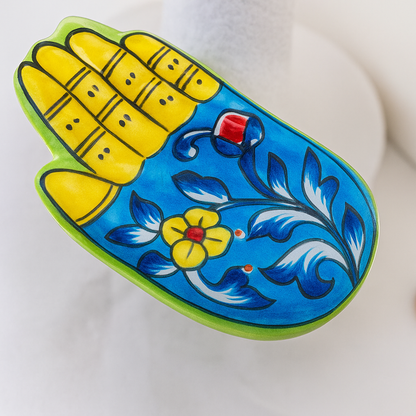 Decorative item with floral design and yellow corn-like elements on a white background