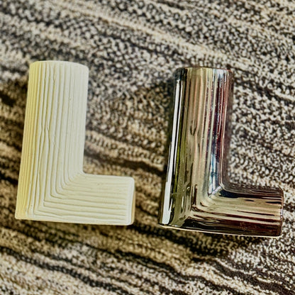 Metallic 'L' shaped object on a textured surface