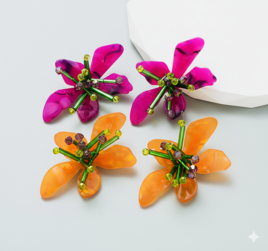 Two pairs of colorful flower-shaped earrings on a white background