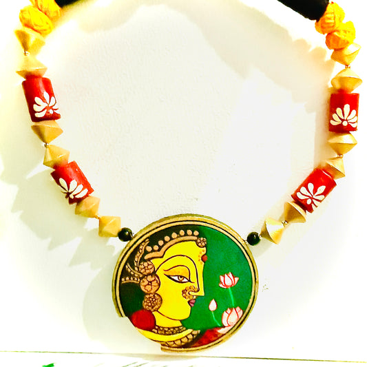Necklace with a decorative pendant featuring a face design on a white background