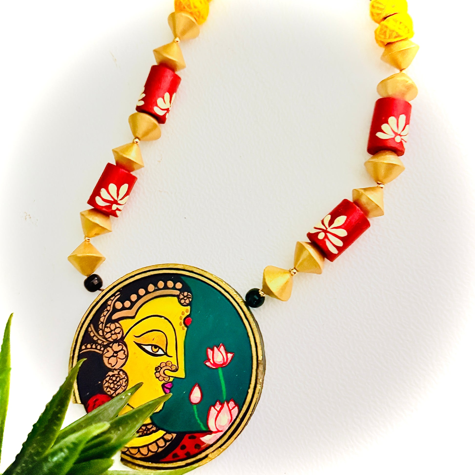 Necklace with decorative pendant featuring a face design on a white background