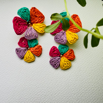Colorful yarn flower earrings on a textured white background