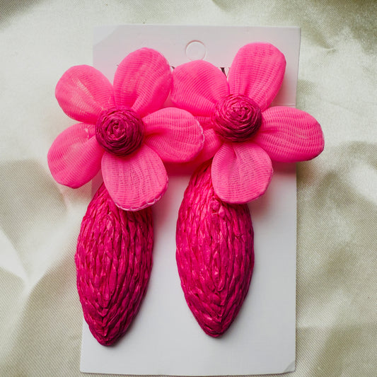 Pair of pink flower-shaped hair clips on a white card with a beige background