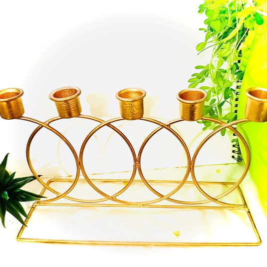 Gold candle holder with five circular holders on a white background