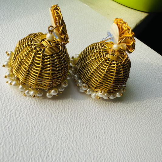 Gold earrings with pearl accents on a white surface