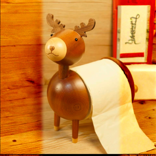 Wooden deer-shaped paper towel holder with a roll of paper towels on a wooden surface.