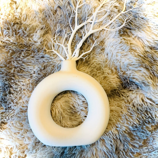 Decorative wall piece with a white tree-like structure on a textured beige surface