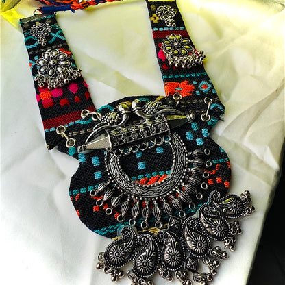 Decorative belt with intricate silver designs and colorful patterns on a white fabric background