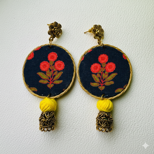 Pair of earrings with floral design and yellow tassels on a white background