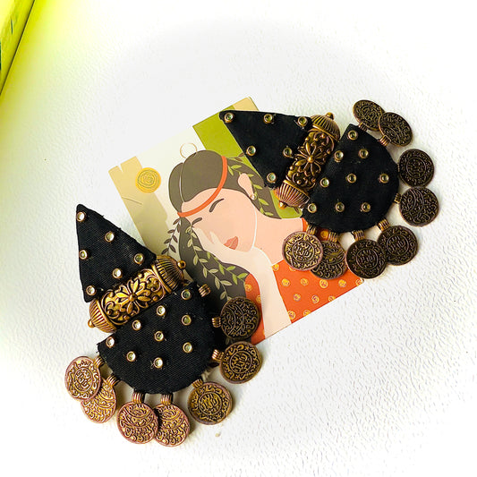 Decorative hair clip with black and gold details on a white background