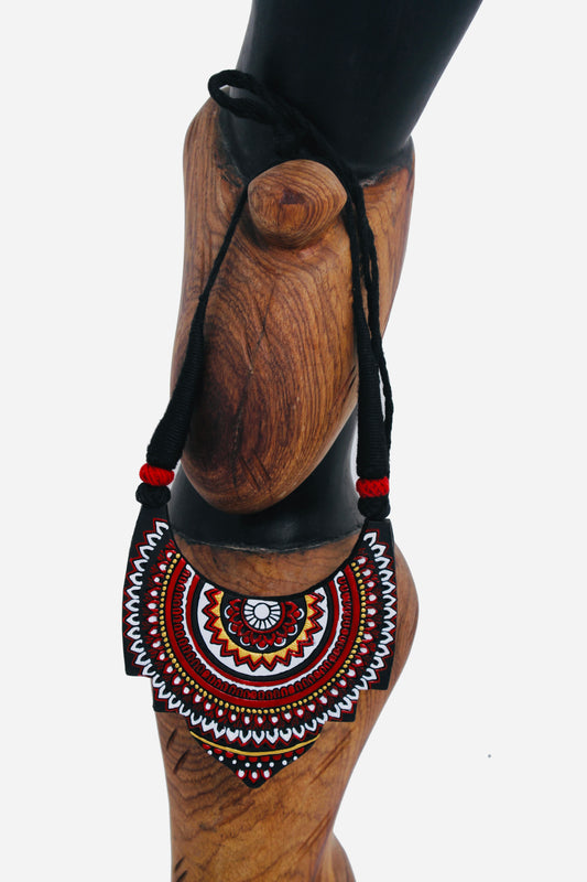 Decorative handbag with intricate patterns on a wooden mannequin against a white background