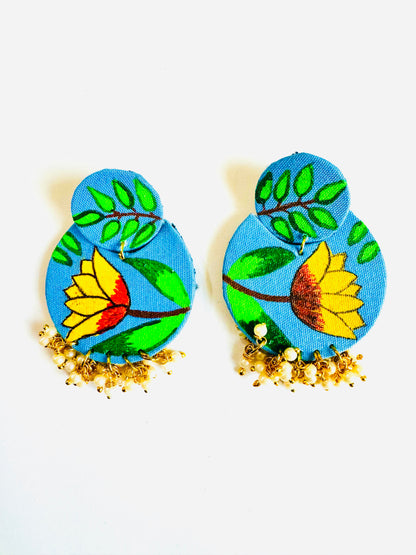 Pair of blue earrings with floral designs on a white background