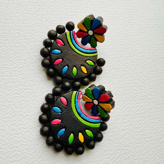 Pair of black earrings with colorful floral designs on a white background