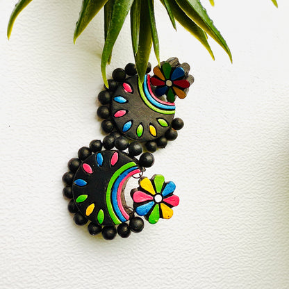 Colorful earrings with black beads on a white background