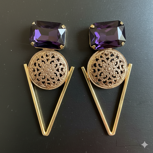 Pair of gold earrings with purple gemstones on a black background
